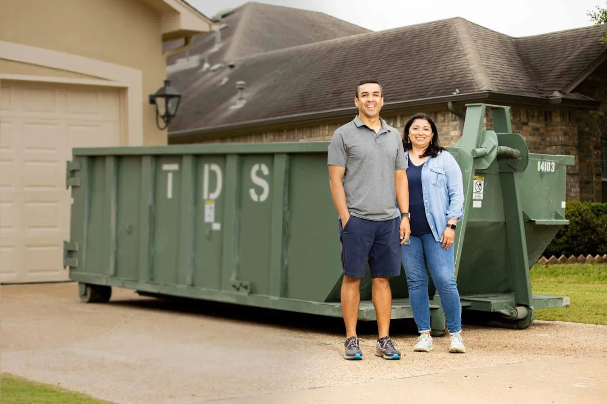 happy couple with dumpster at their back